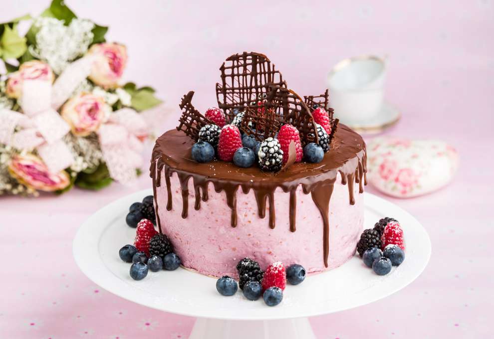 Waldbeer-Joghurt-Torte mit Schokoladenglasur und frischen Früchten